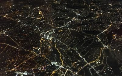 Looking down through the night sky to electric London Land .