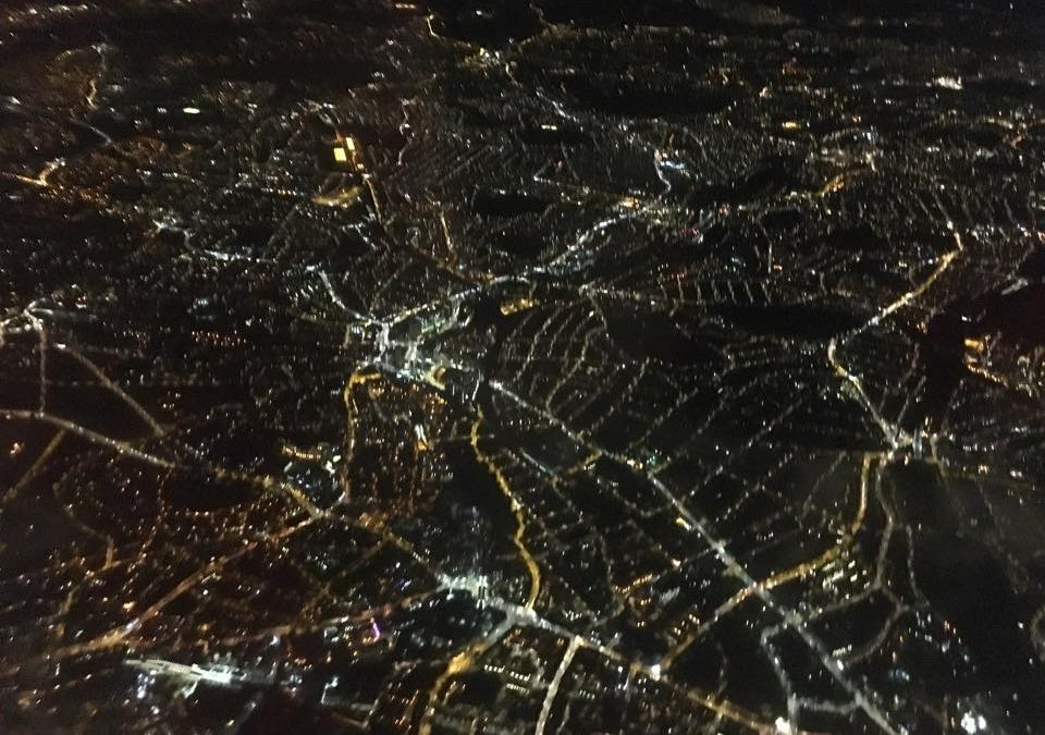 Looking down through the night sky to electric London Land .